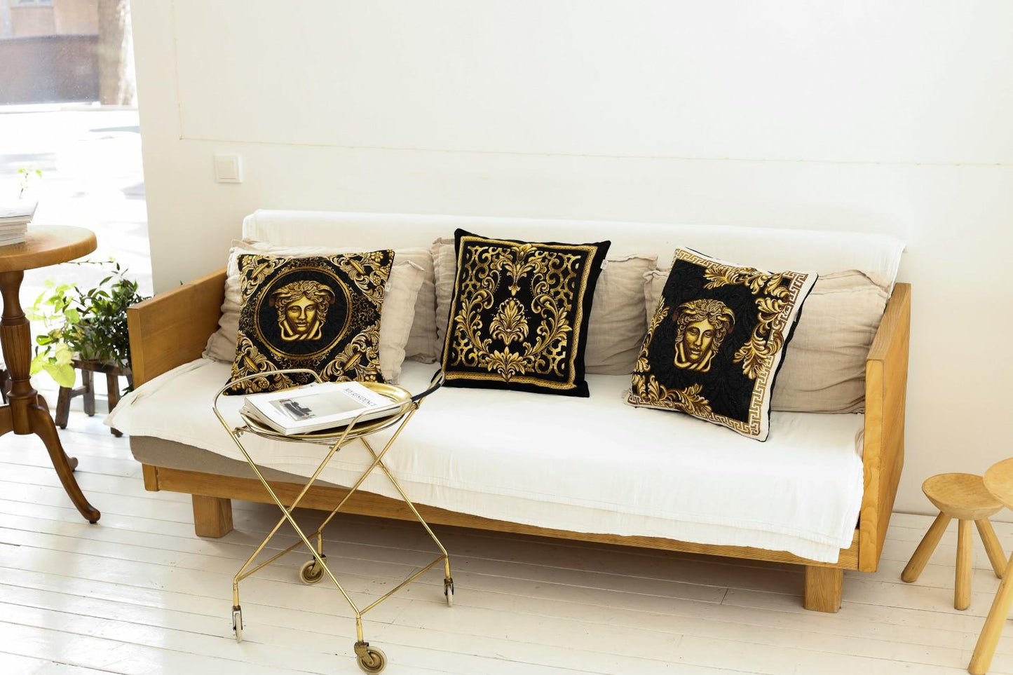 Baroque black and gold tapestry pillows with Medusa design on sofa