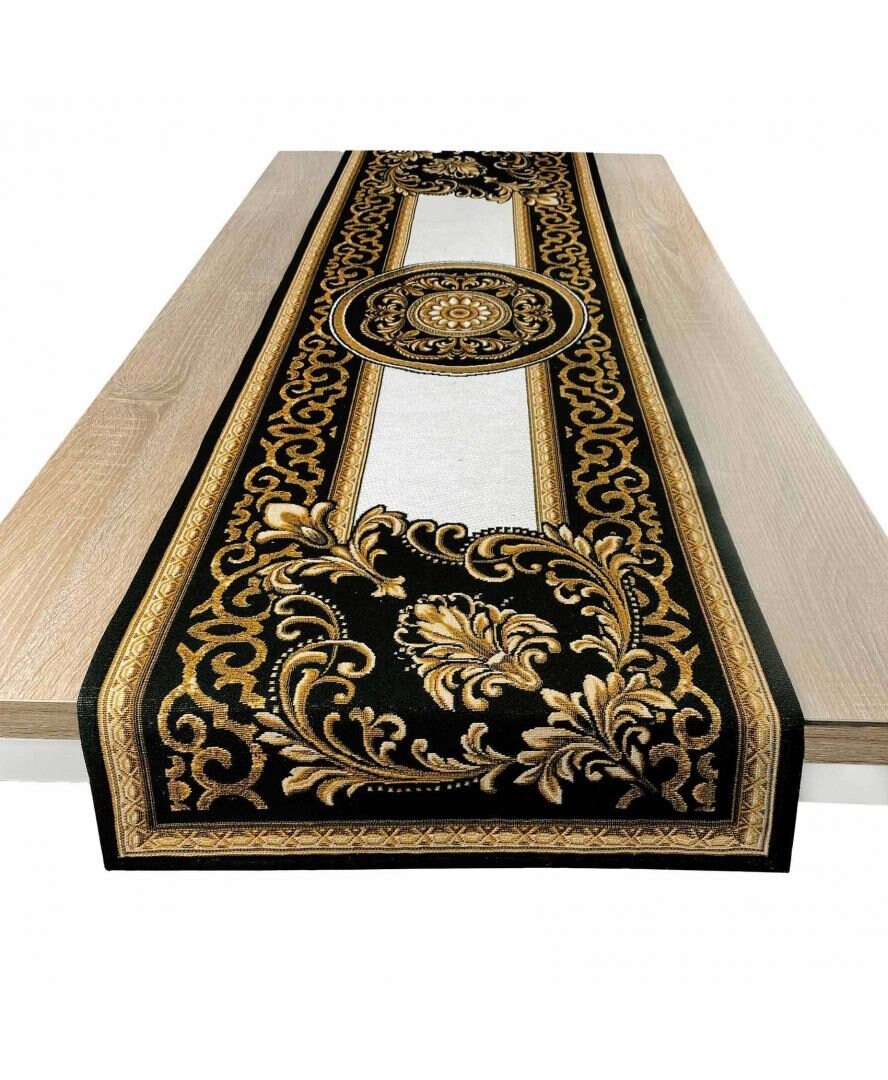 Baroque-style black and gold tapestry table runner with central medallion displayed on a wooden table.