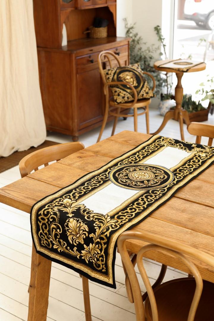 Baroque black and gold tapestry table runner styled on a wooden table in a classic interior
