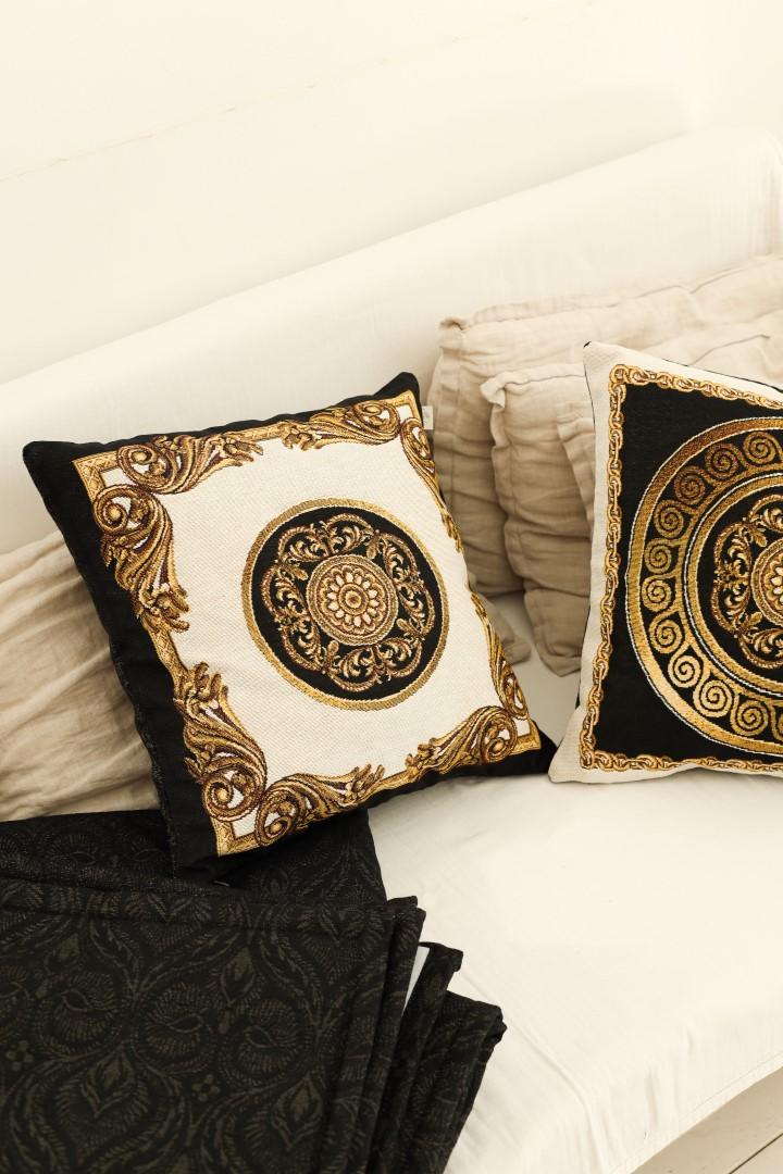 Baroque tapestry decorative pillows in black, gold and white on a sofa