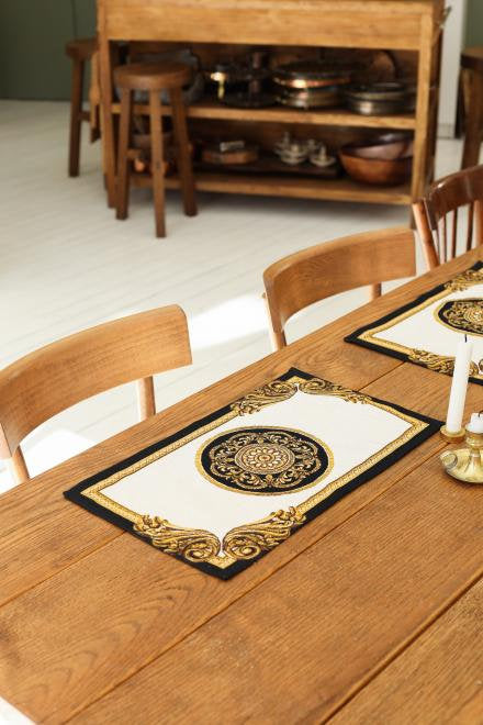 Baroque tapestry placemat styled on a wooden dining table in a warm interior