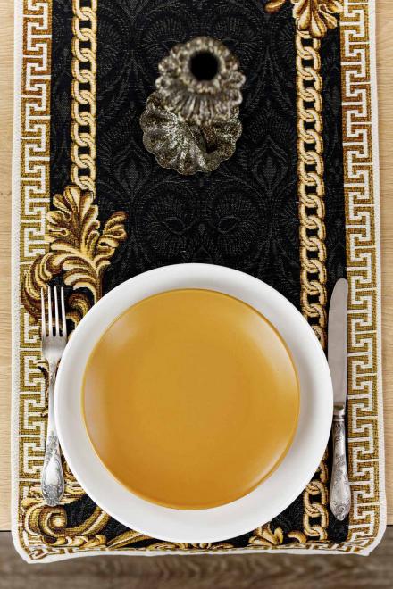 Black and gold baroque table runner styled with a cup of tea on a wooden table