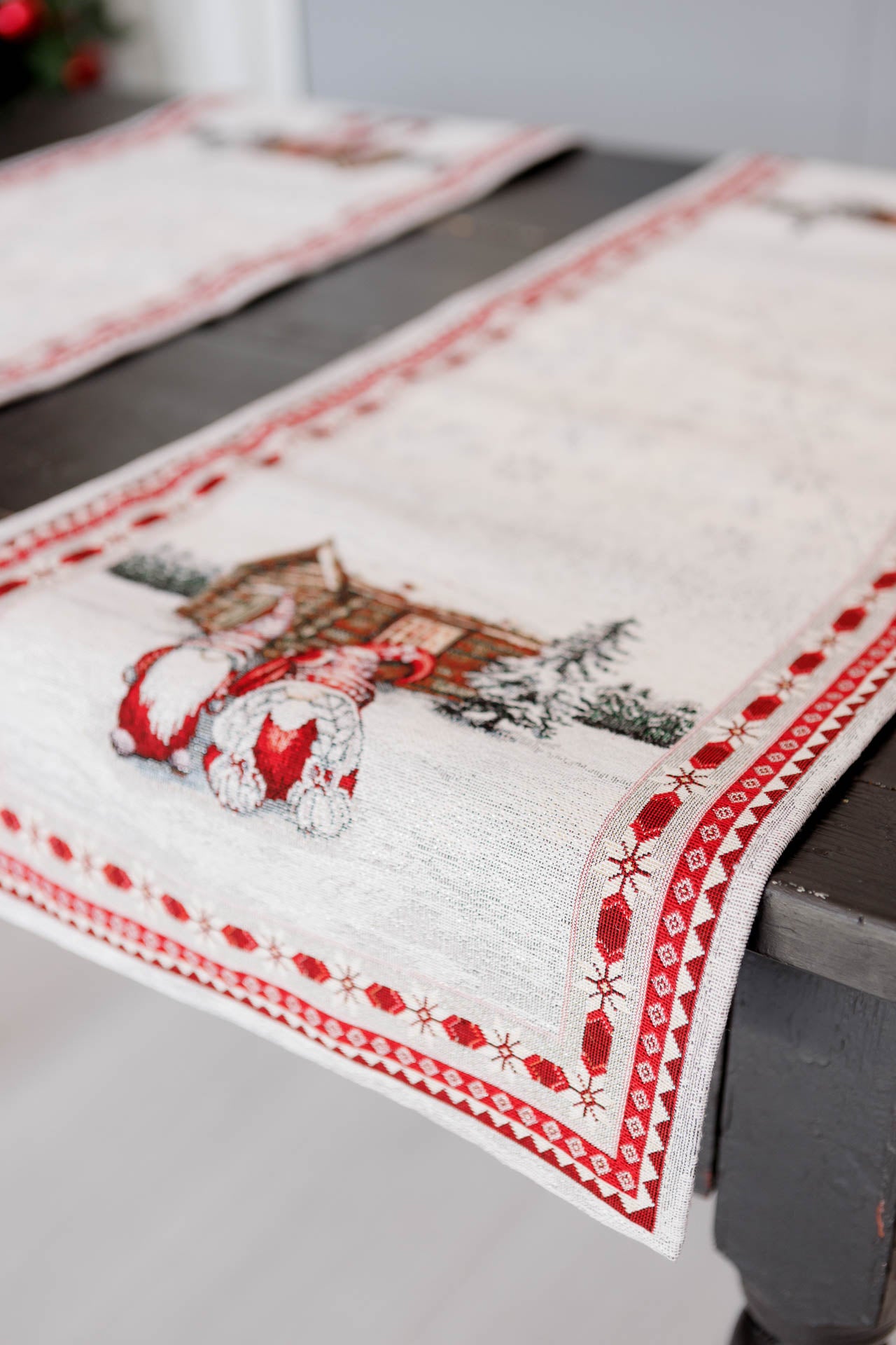 Close-up of Christmas gnome tapestry runner on table highlighting woven winter scene.
