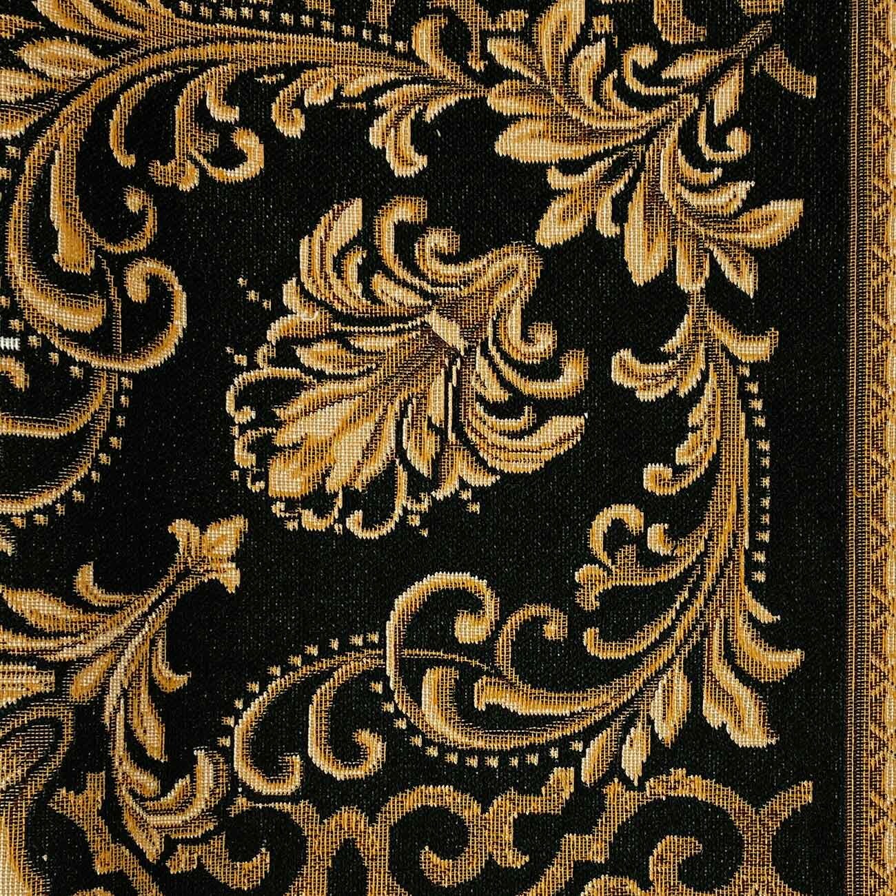 Close-up of black and gold baroque tapestry fabric showing woven floral ornament and decorative border
