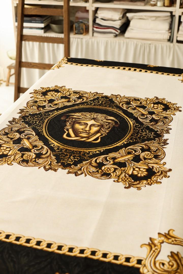 Close-up of gold and black baroque tablecloth with Medusa design