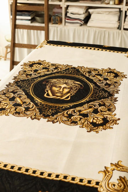 Close-up of gold and black baroque tablecloth with Medusa design