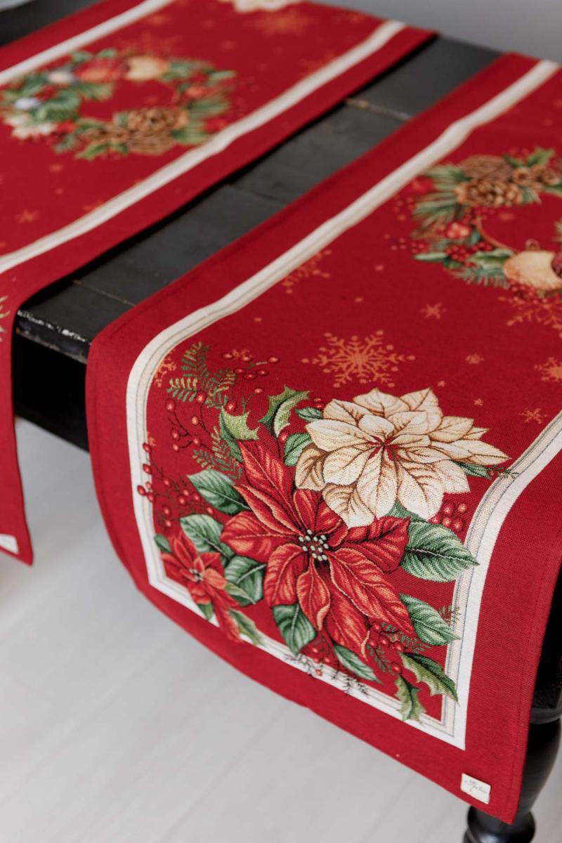 Close-up of poinsettia flower and baubles woven in red tapestry Christmas table runner pattern