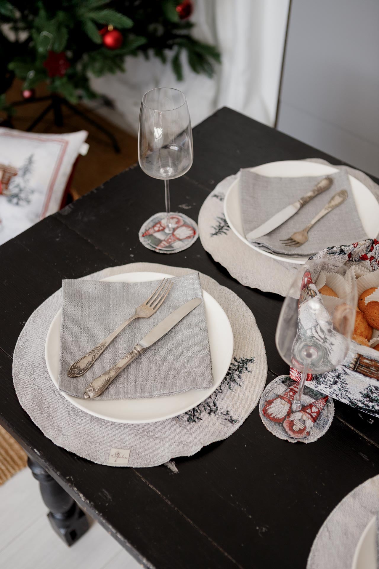 Close-up of silver Christmas tapestry placemat under dinner plate with grey napkin