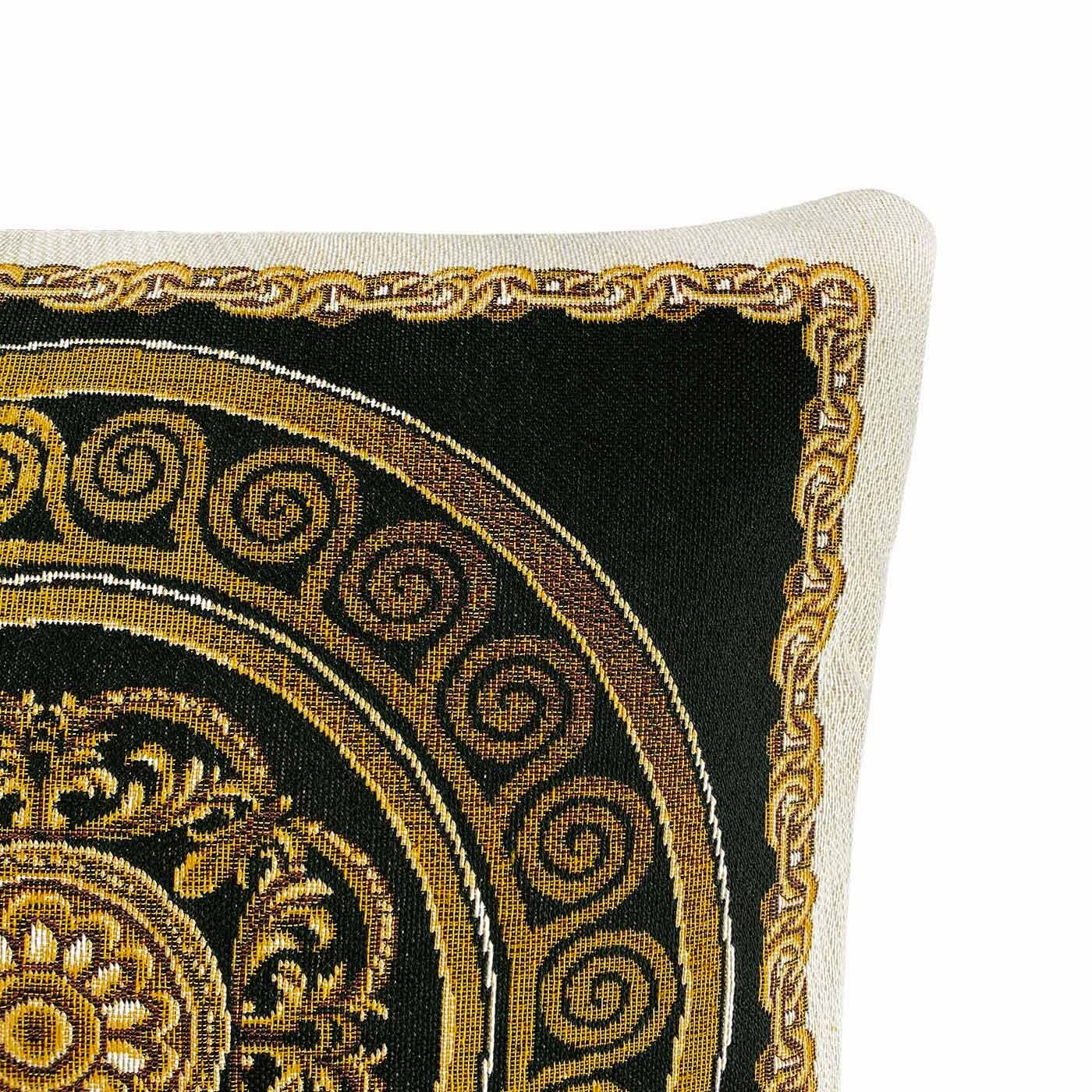 Close-up of the black baroque tapestry pillow showing detailed gold medallion and scrollwork pattern.
