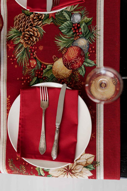 Close-up of woven tapestry fabric with poinsettia flowers, Christmas wreath, and gold ornaments.