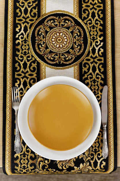 Decorative table setting with black and gold tapestry table runner, white plate and silver cutlery
