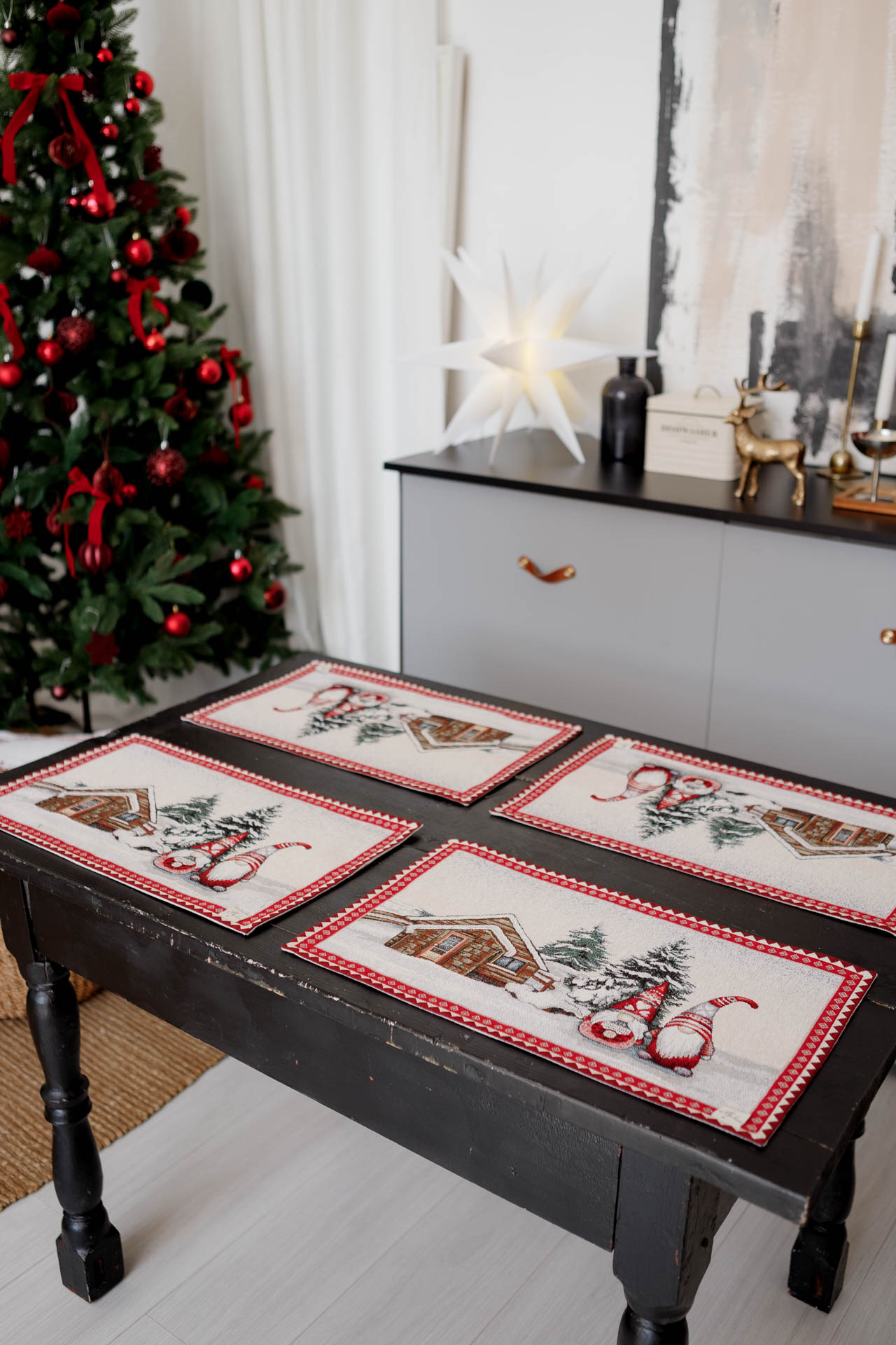 Detailed view of woven gnomes and snowy cottage design on Christmas tapestry placemat