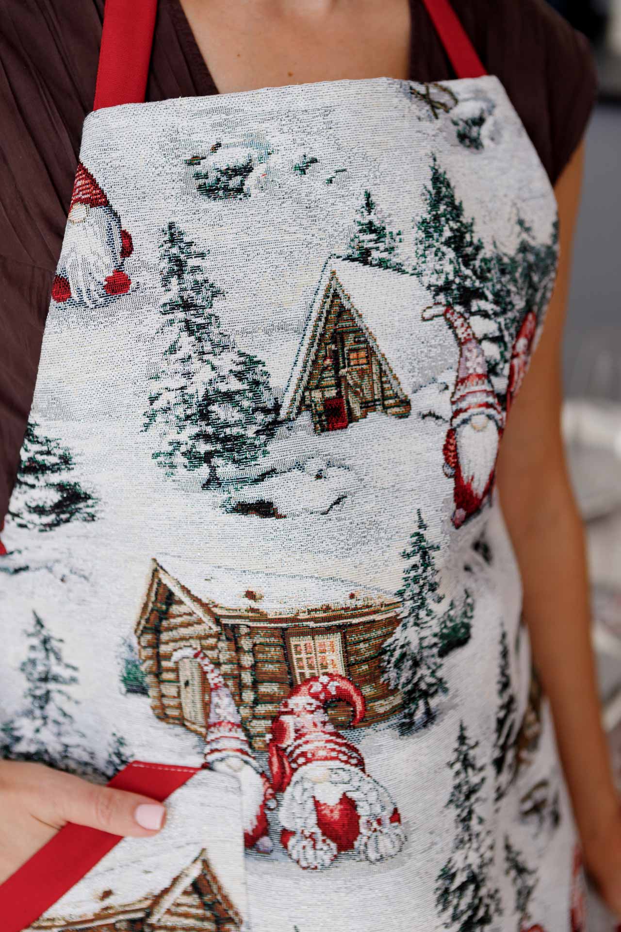 Detailed view of woven tapestry fabric with gnome and winter cottage pattern