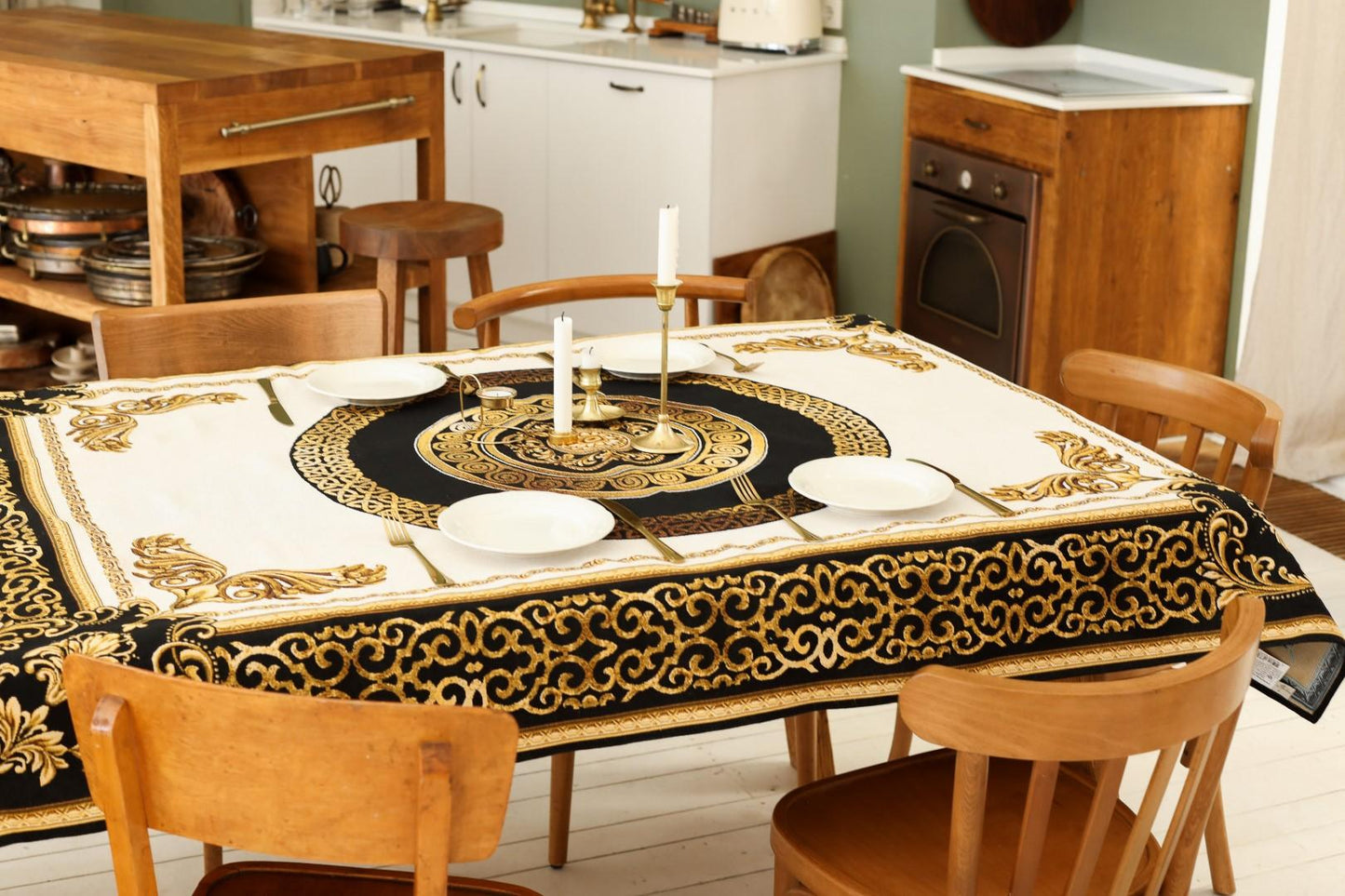 Dining table decorated with baroque gold and black tapestry tablecloth and candles.