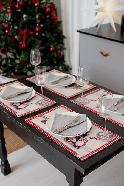 Dining table set with Christmas gnome tapestry placemats, plates, napkins, and wine glasses