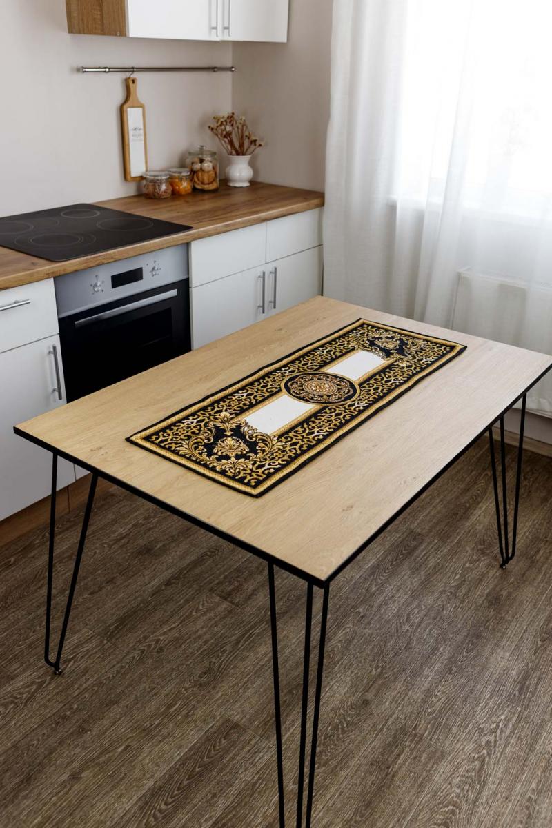 Elegant black and gold tapestry table runner in a modern kitchen interior on a wooden table