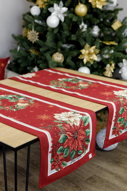 Elegant red Christmas table runner with poinsettia and ornament design on festive table