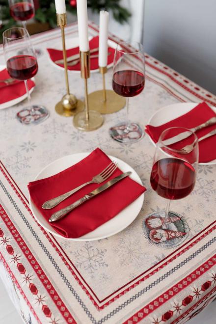 Festive dining setup on white tapestry tablecloth with candles