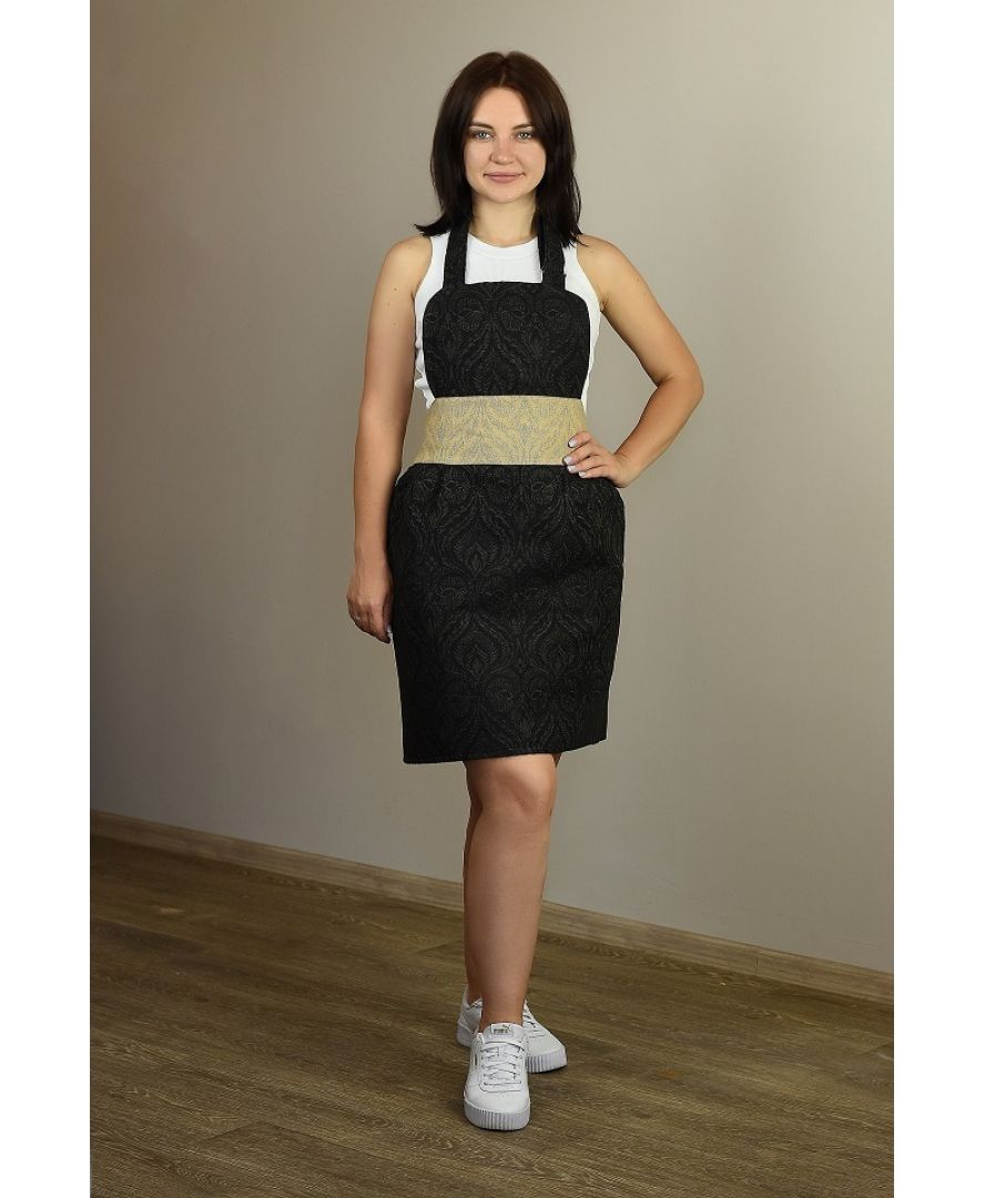 Full-length view of a woman wearing a black baroque apron with gold accent in a kitchen setting