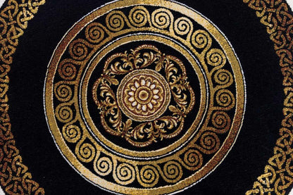 Gold medallion and spiral pattern on black tapestry fabric, detailed macro view.