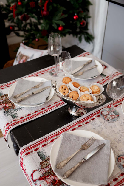 Holiday place setting with gray napkins and vintage cutlery on Christmas woven table runner.