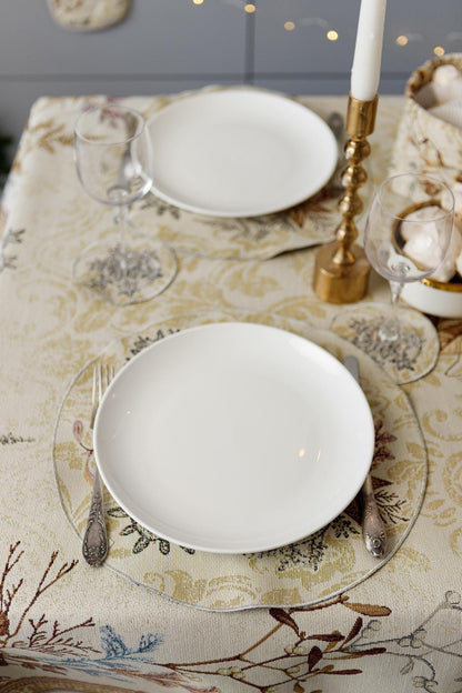 Round Christmas tapestry placemat with poinsettia floral design. Beige and gold festive holiday table decor.