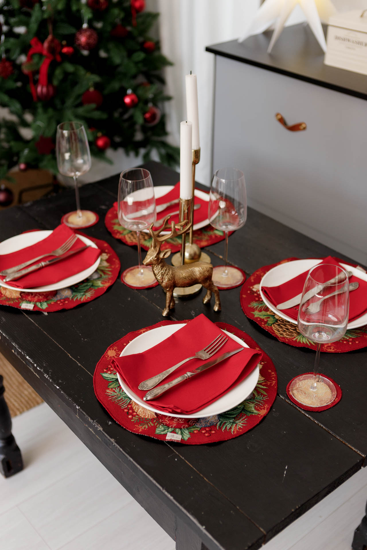 Round holiday placemats on dining table with festive decor and candles