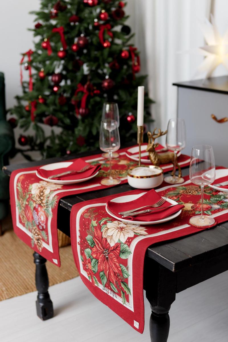 Side view of red Christmas tapestry table runner draping over a dining table edge.