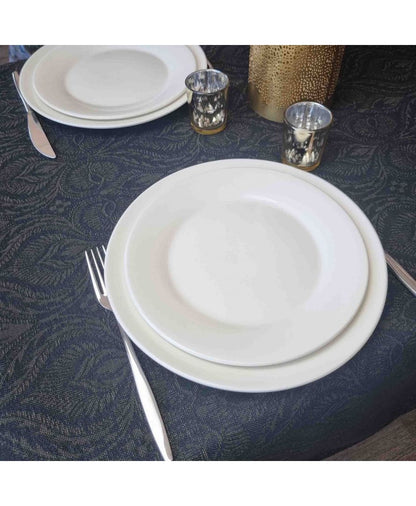 Table setting with white plates on a dark textured jacquard tablecloth
