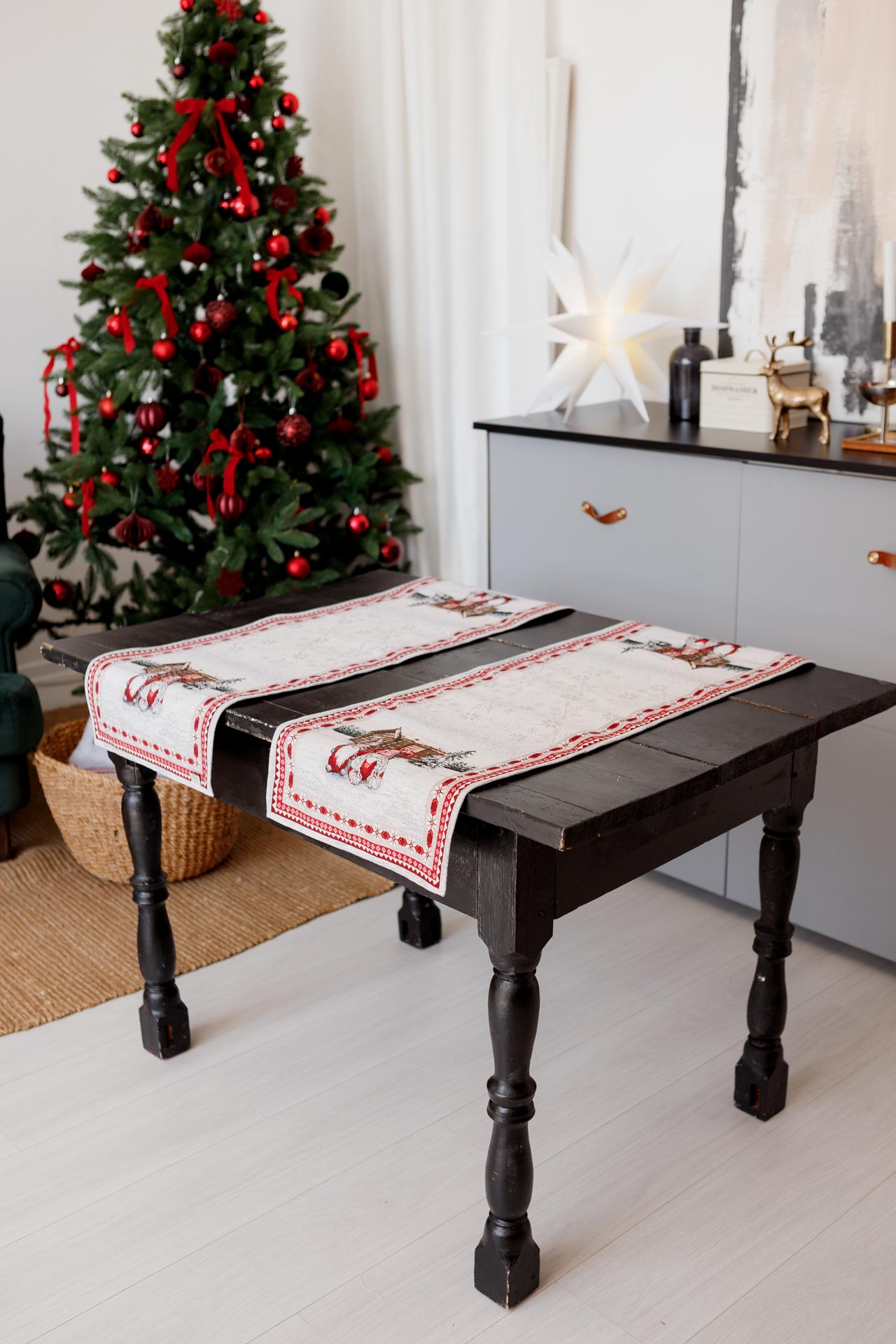 Two Christmas tapestry runners displayed side by side on wooden table in holiday interior.