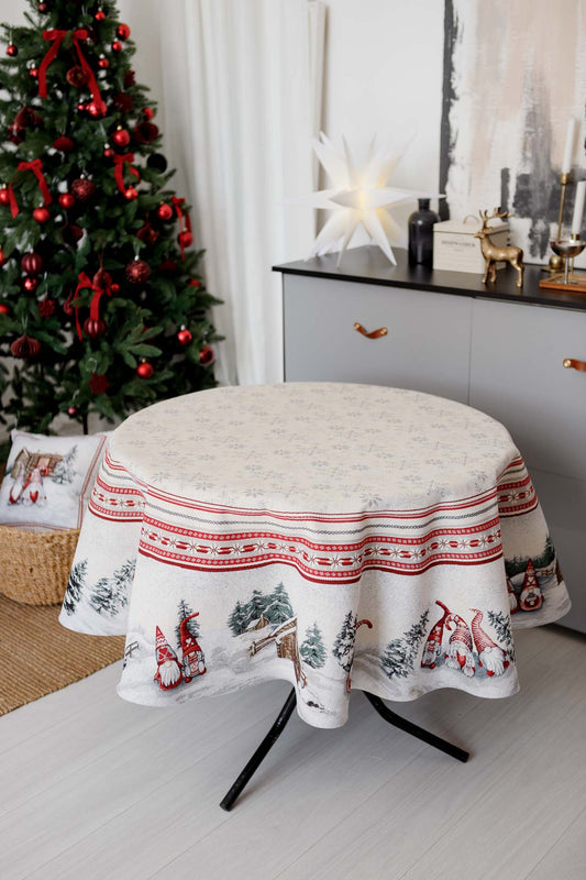 White tapestry holiday tablecloth with gnomes near Christmas tree