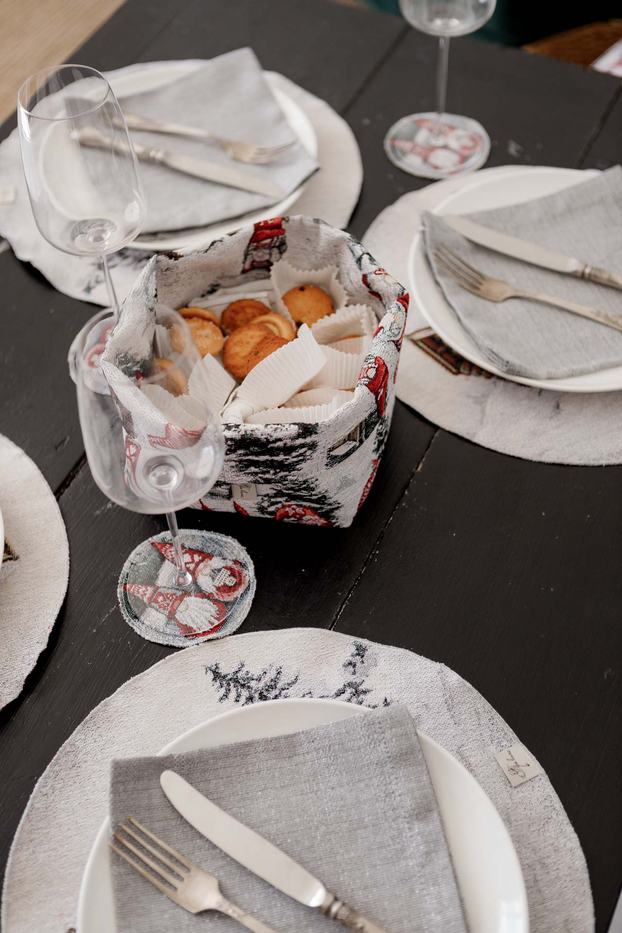 Wine glass on Christmas coaster with matching tapestry placemat beneath plate