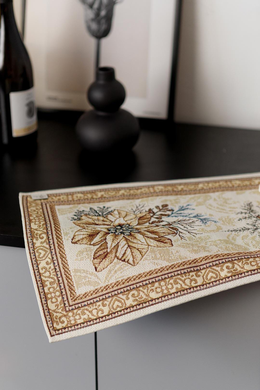 Woven tapestry placemat with Christmas poinsettia flower design. Beige and gold. Made in Ukraine.