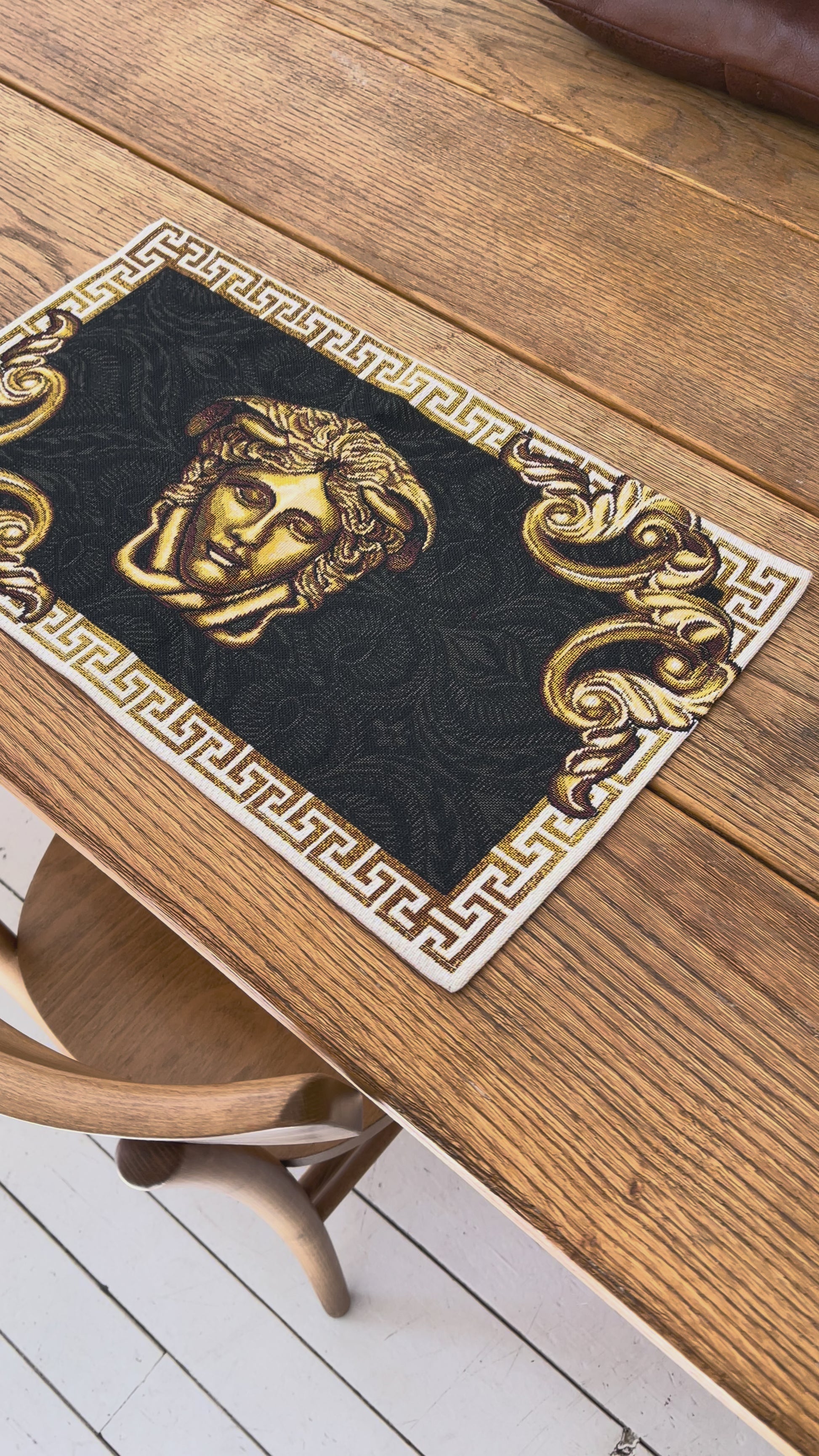 Video of Black and gold baroque tapestry placemat with Medusa head detail and ornate border
