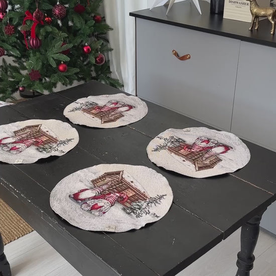 Video of Set of four round Christmas placemats displayed on a rustic dark wooden table near a decorated Christmas tree